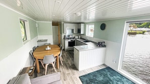 Een compacte keuken met een eethoek, een klein kookeiland en uitzicht op het water.