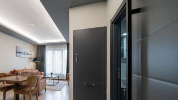 Ein modernes Wohnzimmer mit Essbereich, einer großen, dunkel gefärbten Tür und Blick durch eine Glastür.