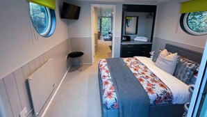 Een moderne slaapkamer met een bed, nachtkastje en spiegel.