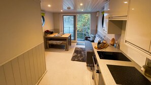 Een moderne keuken met een eethoek, een groot raam en uitzicht op het omliggende landschap.