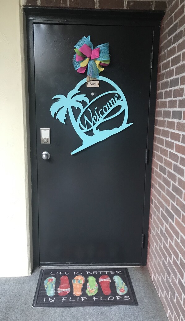 A door with a welcome sign and a number plate. - 3 bedroom, 3 bath beautiful oceanfront condo on the quiet shore of Cherry Grove. (North Myrtle Beach)