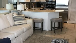 A modern kitchen with white cabinets, stainless steel appliances, and a central island. - 3 bedroom, 3 bath beautiful oceanfront condo on the quiet shore of Cherry Grove. (North Myrtle Beach)