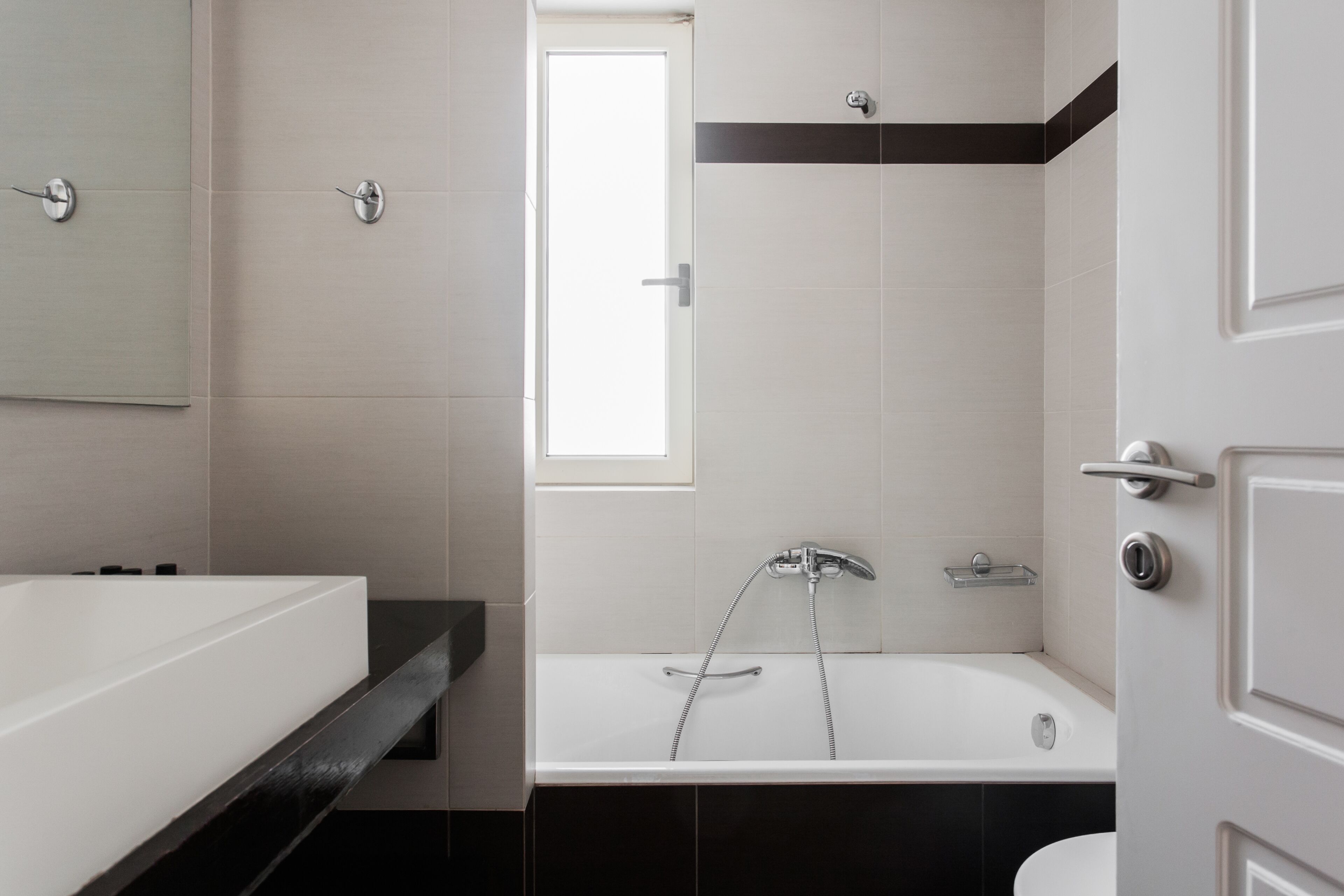 A modern bathroom with a white bathtub, a separate shower area, and a large mirror.