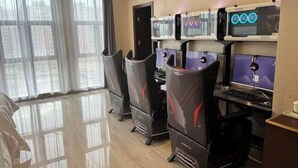 A gaming room with multiple gaming stations, each with a monitor and a chair. - Vienna International Hotel Kunshan Lujia Shentongyu Subway Station (Kunshan)