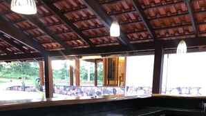 Un espace extérieur abrité, doté d’un sol carrelé en pierre et d’un comptoir noir.