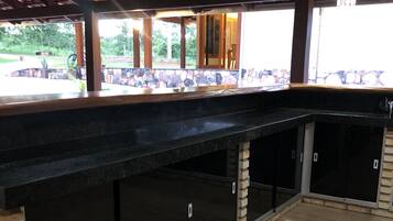 Un espace extérieur abrité, doté d’un sol carrelé en pierre et d’un comptoir noir.