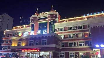 A multi-story hotel with a prominent sign, multiple windows, and a flat roof.