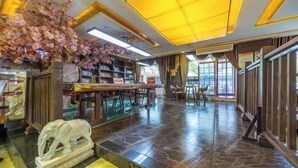 A library with bookshelves, a statue, and a large window. - Yunxiang International Hotel (Wuwei)