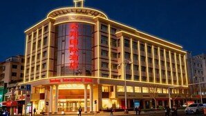 A hotel with a prominent vertical sign, a large entrance, and a well-lit facade. - Yunxiang International Hotel (Wuwei)