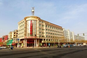 A multi-story hotel with a prominent entrance and a flagpole.