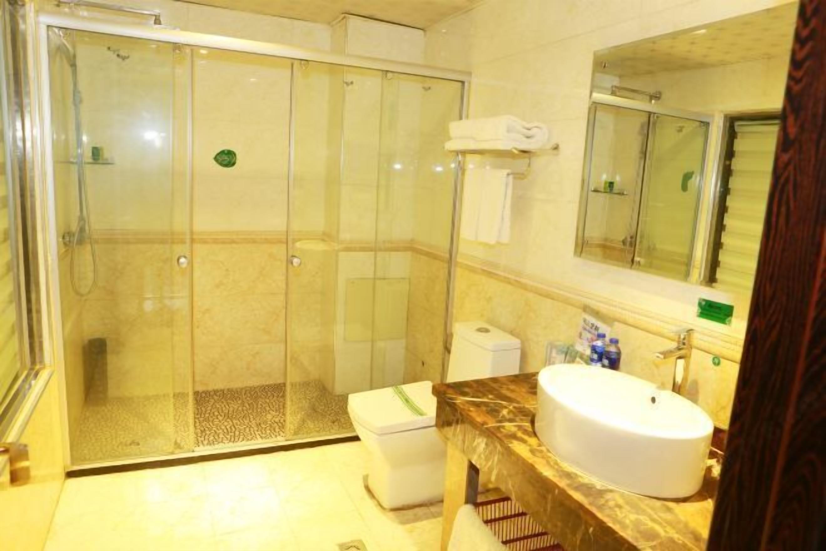 A bathroom with a glass-enclosed shower, a white sink, and a mirror above the sink.