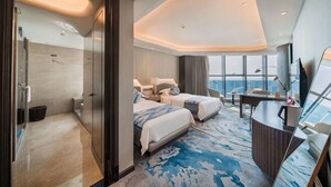 Ein modernes Hotelzimmer mit einem großen Bett, einem Schreibtisch und Blick auf die Stadt.