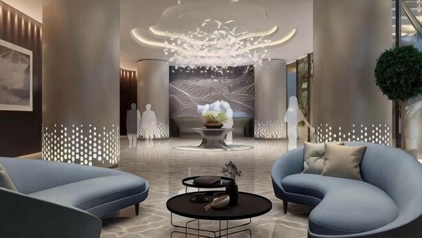 Eine moderne Lobby mit einer zentralen Sitzecke, einer dekorativen Decke und einem großen Wandbild.