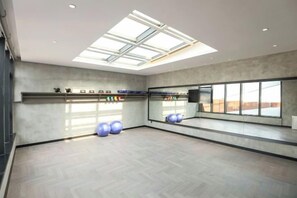 A spacious room with a skylight, exercise balls, and a large mirror. - Puyuan F GINLAN JIA Hotel (Tongxiang)