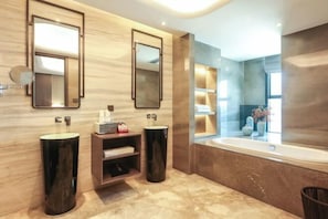 Un baño moderno con dos lavamanos, un espejo grande, un tocador con estantes y una bañera.