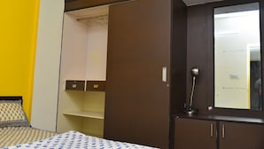 Un dormitorio con cama, armario, espejo y mesita de noche.