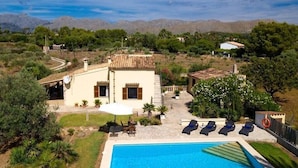Uma vila com piscina, área de estar externa e vista para montanhas.
