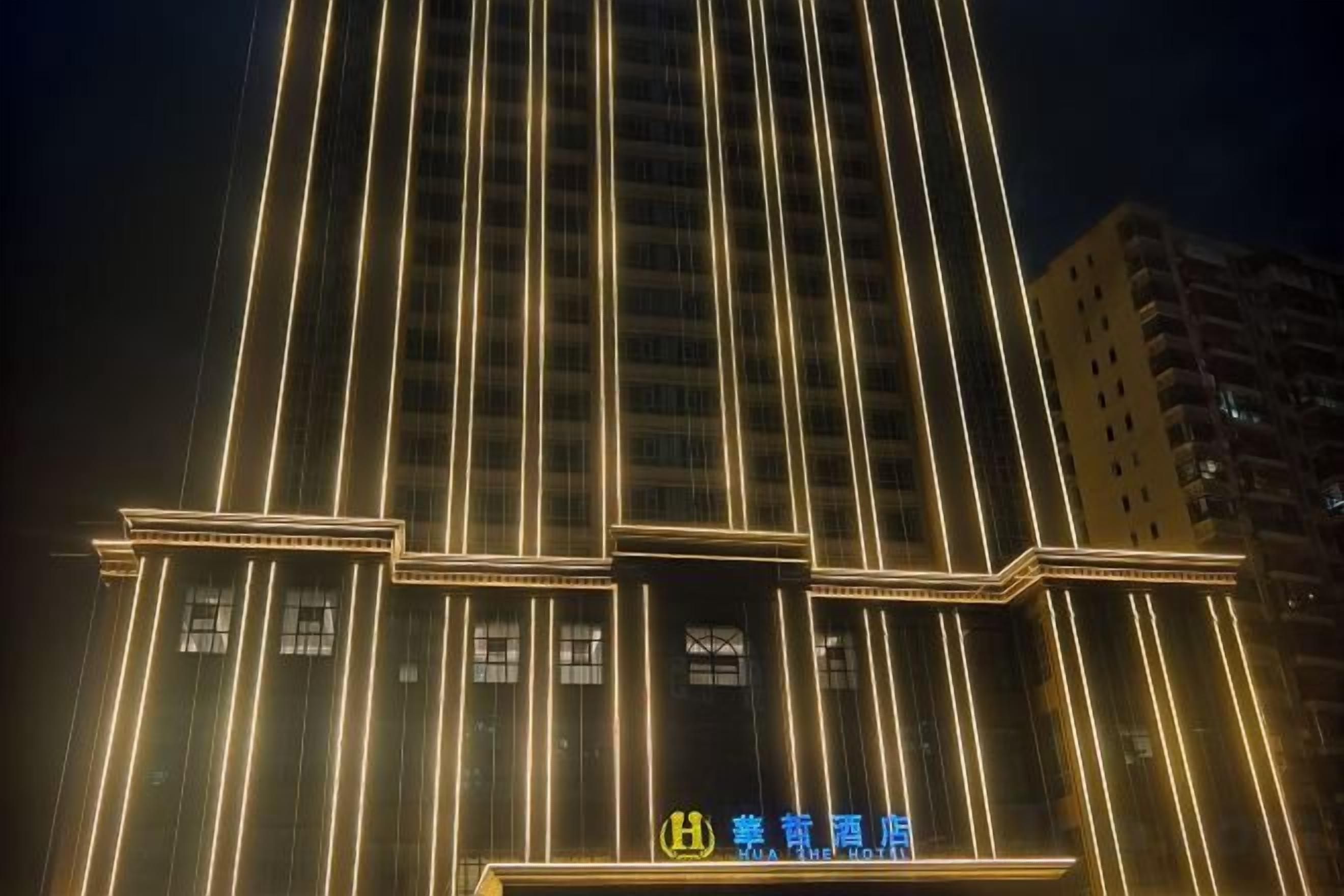 Un edifici alt amb línies verticals il·luminades i un senyal amb caràcters xinesos.