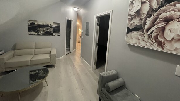 A modern living room with a sofa, a coffee table, and a chair. There are two doors leading to other rooms. - Kid friendly neighborhood!  Everyone is welcomed in this cozy apartment home! (Springfield)