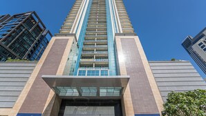 Un immeuble de grande hauteur doté d’une architecture moderne, avec une entrée imposante, des portes en verre et une enseigne indiquant « 8, boulevard Walk ».
