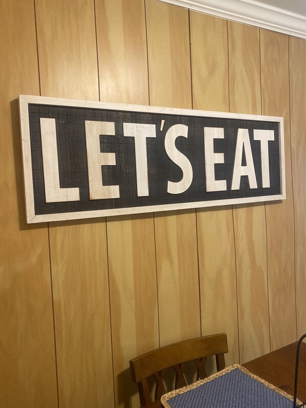 A wooden wall with a sign that reads "LET'S EAT". - Entire Unit (Conway)