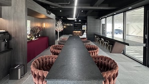 A modern hotel lobby with a long reception desk, plush seating, and large windows offering views of the street. - Hotel 24st Urban Brown Seosan Lake Park (Seosan)