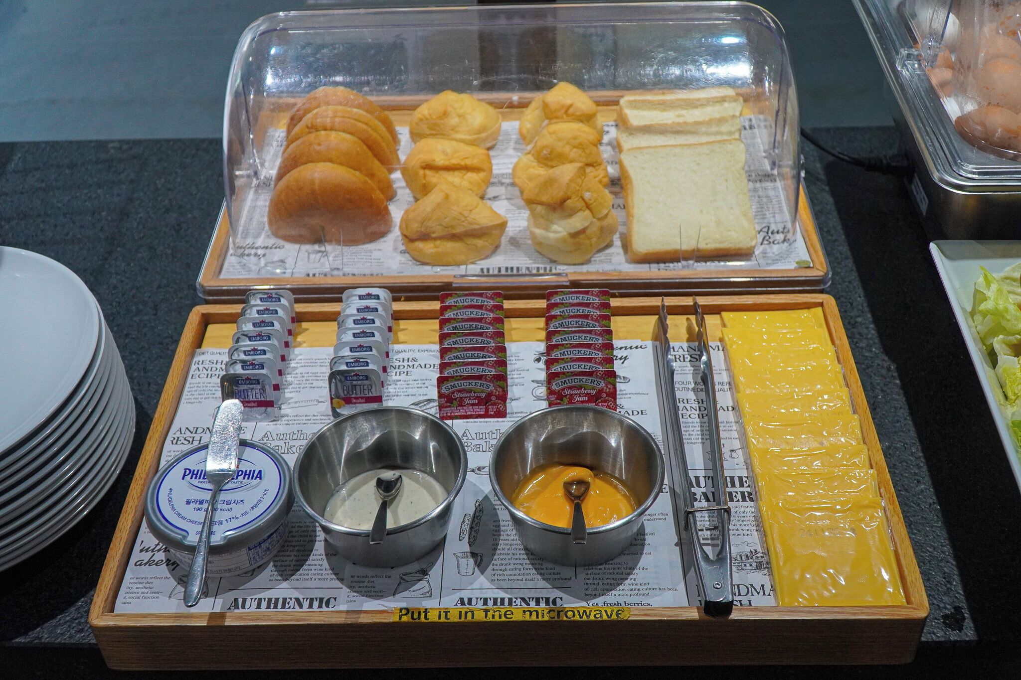 Una mesa de buffet con diferentes productos de pastelería, salsas y utensilios.