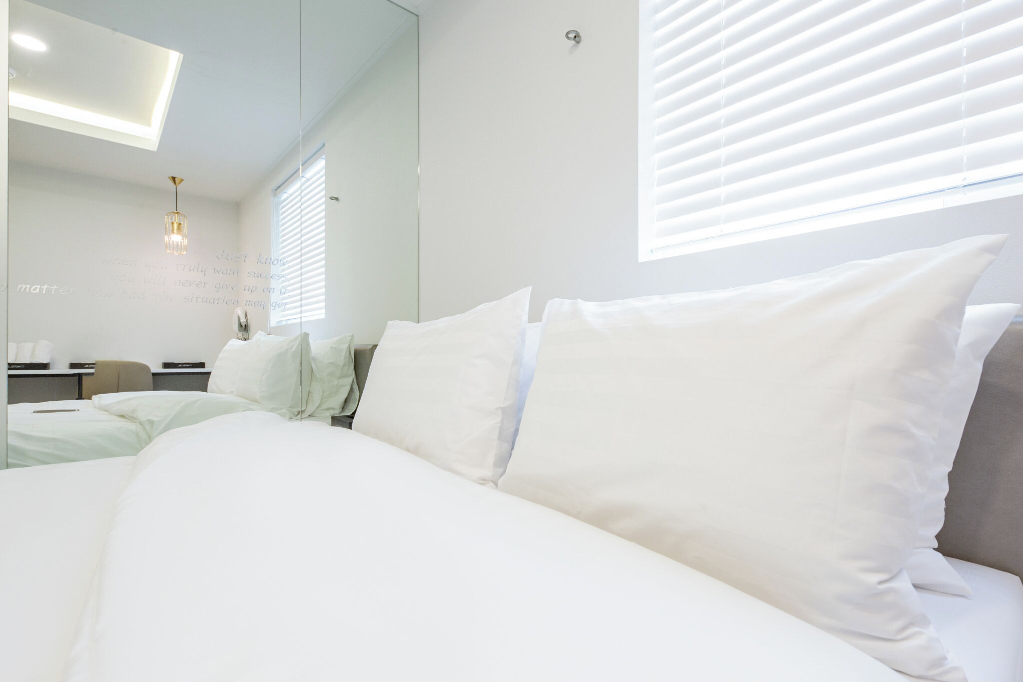A hotel room with a large bed, a desk, and a chair.
