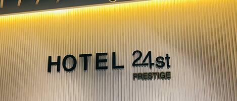 A wall with the text "HOTEL 24st PRESTIGE" indicating the name and type of the hotel.