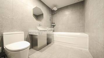 Un baño moderno con inodoro, lavamanos y bañera.