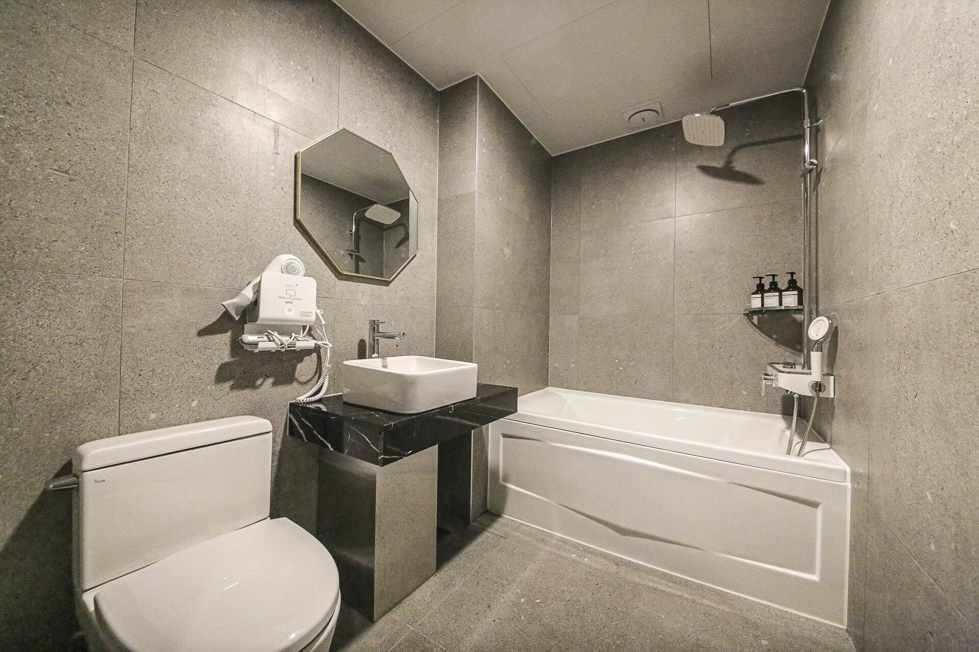 A modern bathroom with a toilet, sink, and bathtub.