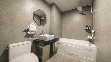 A modern bathroom with a toilet, sink, and bathtub.