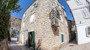 A narrow stone building with a green door and a sign that reads "HOTEL". - Old Town Apartment Dan (Budva)