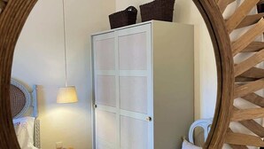 A bedroom with a bed, a nightstand, a lamp, a wardrobe, and a mirror with a wooden frame. - Gaya Avenue 102 - Flat w/ Balcony (Vila Nova de Gaia)