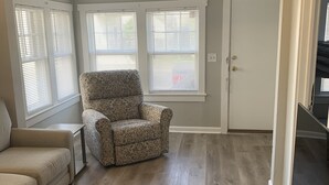 A living room with a patterned armchair, a sofa, and a door. - Two bedroom private home less than 1 block away from the beach (Seaside Park)