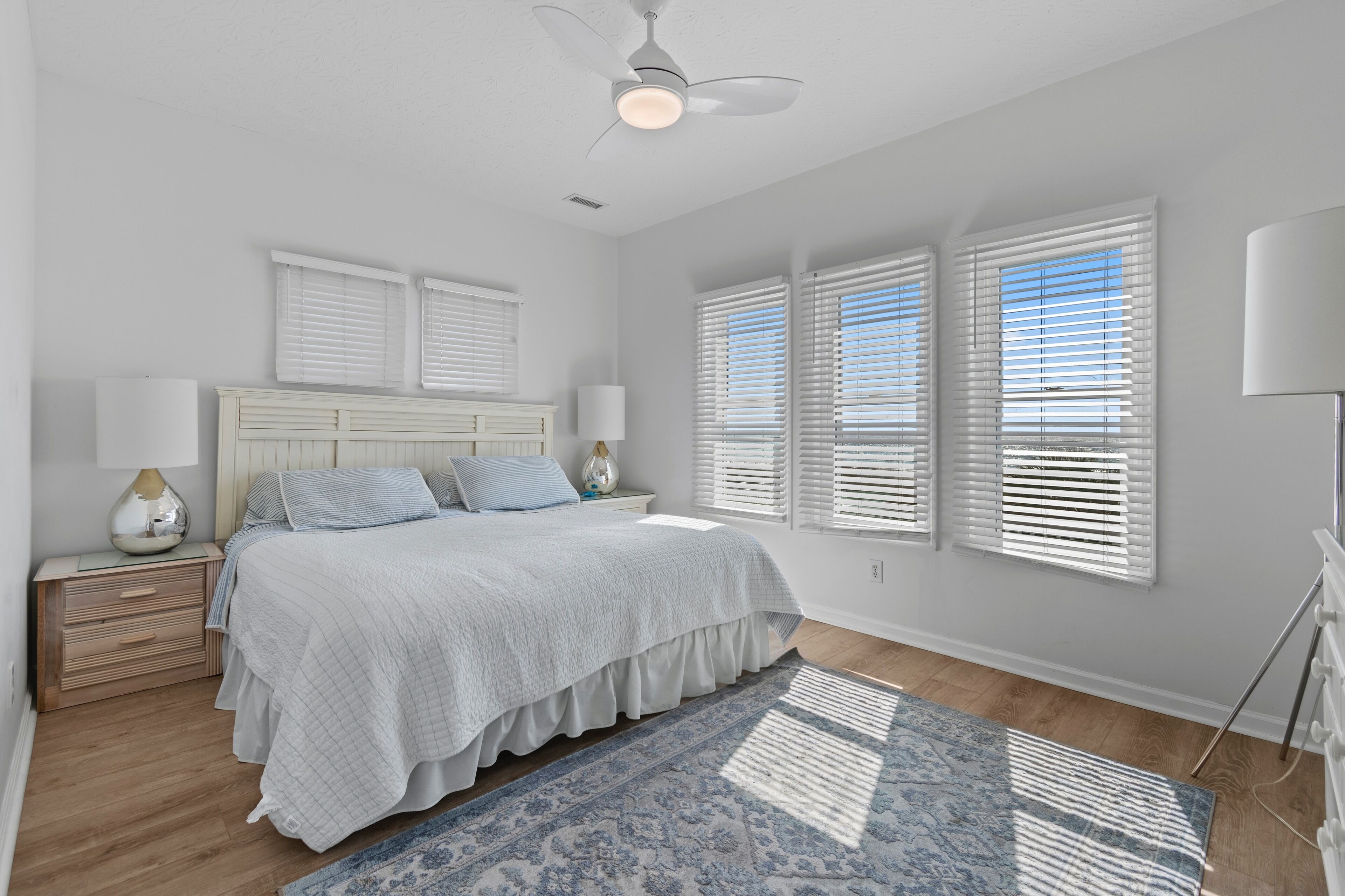 Master bed with a king, TV, ensuite bath, and plenty of light