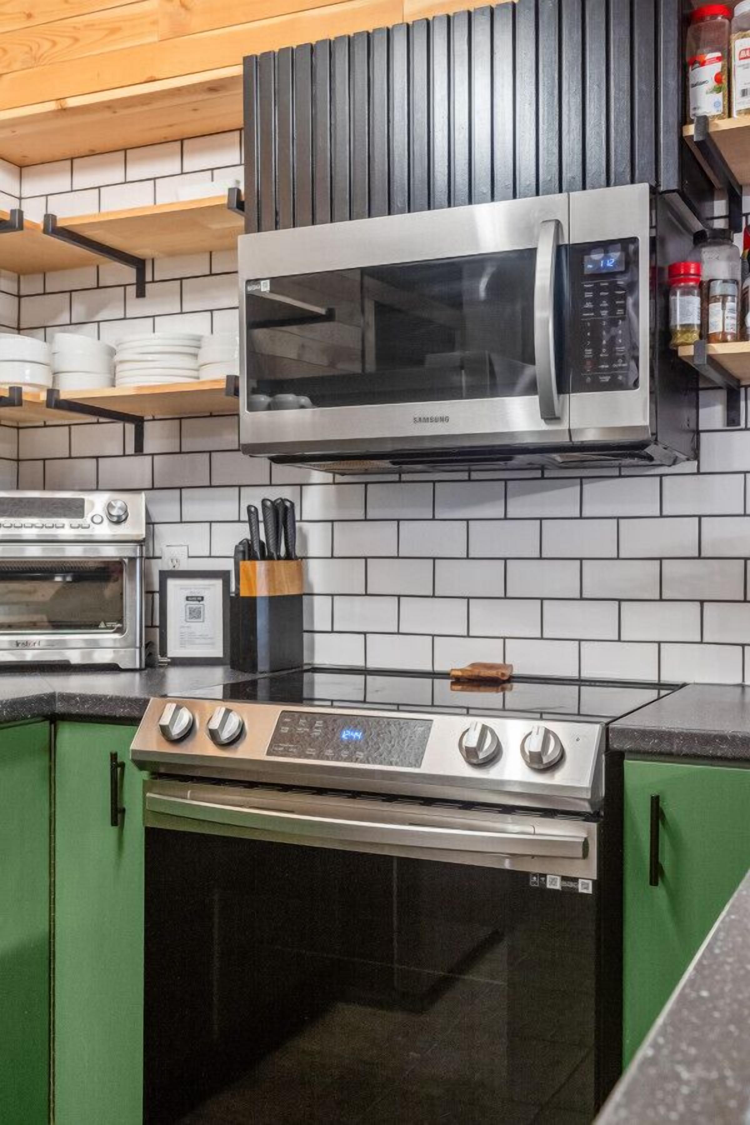 A kitchen with a stainless steel microwave, a built-in oven, and a stovetop.