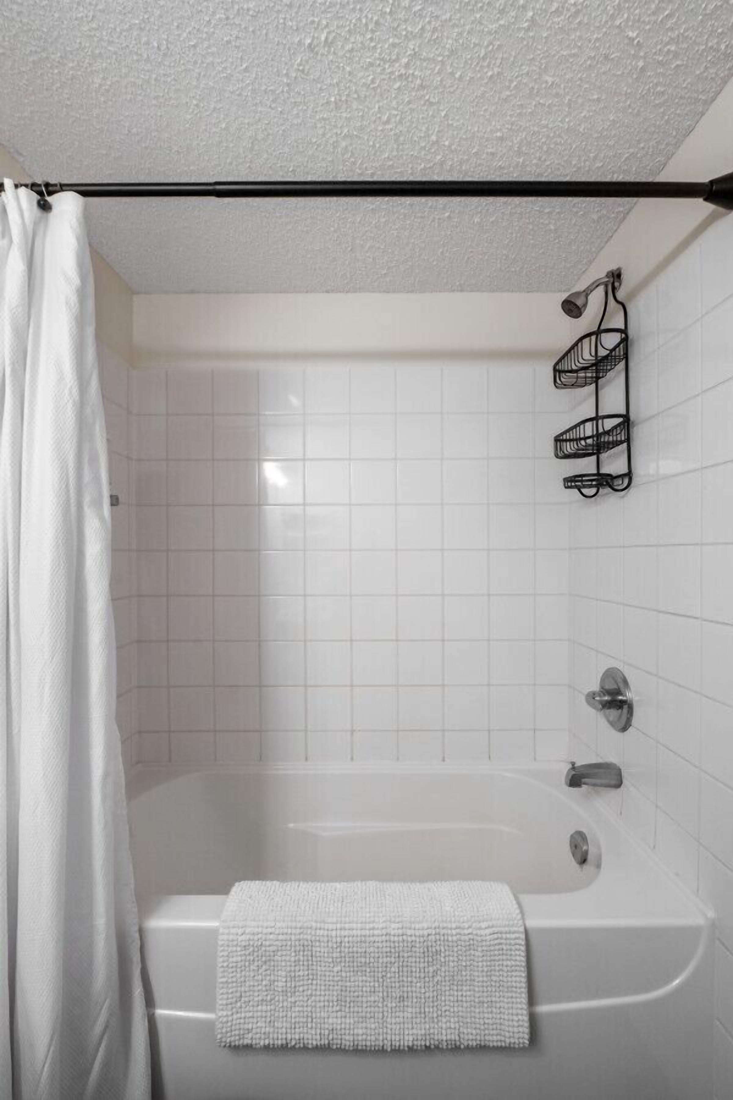 Ein modernes Badezimmer mit einer Badewanne, einer Duschvorhang und einem Handtuchhalter.