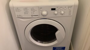 Un lave-linge à chargement frontal, avec un compartiment pour la lessive et l’adoucissant situé sur le dessus.