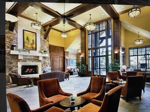 Relax in the hotel's inviting lobby, featuring a fireplace, comfortable seating, and a beautiful painting.