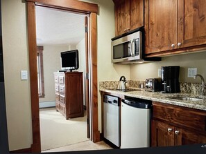 Kitchen area with microwave, coffee maker, and dishwasher.