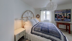 Ein Schlafzimmer mit einem Bett, einem Nachttisch und einem Bild an der Wand.
