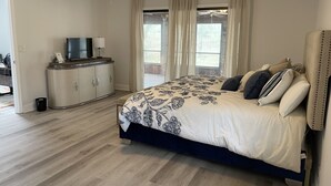 A bedroom with a bed, a TV on a cabinet, and a ceiling fan. - 5 mi to WEC, 10 to HITS -spacious house sleeps 10, big kitchen & 2 sitting areas (Ocala)