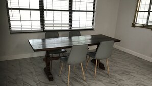 A dining area with a rectangular table, four grey chairs, and a window with blinds. - 5 mi to WEC, 10 to HITS -spacious house sleeps 10, big kitchen & 2 sitting areas (Ocala)