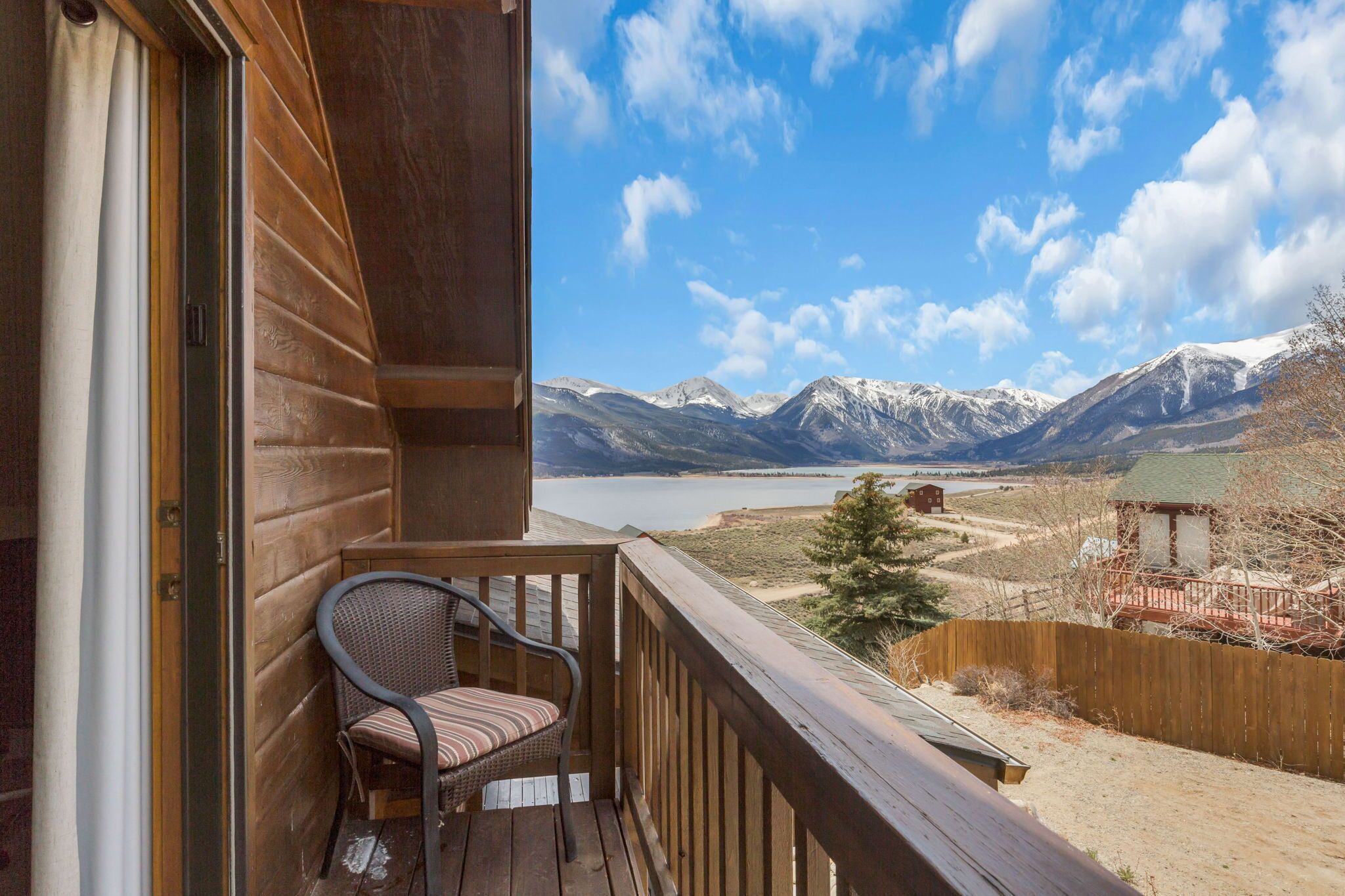 A balcony with a view of mountains and a lake.