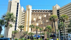 A multi-story hotel with a distinctive architectural design, featuring a central tower and multiple balconies. - 4BR oceanfront, 8th fl, big balcony in Ocean Reef (Myrtle Beach)