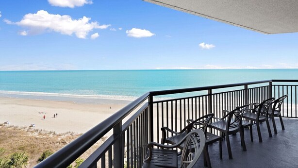 A balcony with a view of a beach and ocean. - 4BR oceanfront, 8th fl, big balcony in Ocean Reef (Myrtle Beach)
