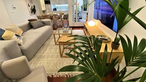 En moderne stue med sofa, sofabord og fjernsyn.