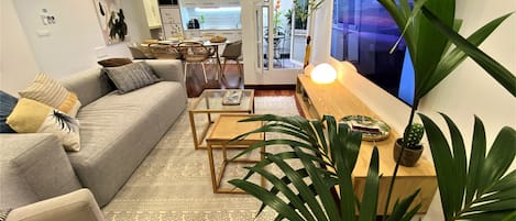 Una sala de estar moderna con sofá, mesa de centro y televisor.