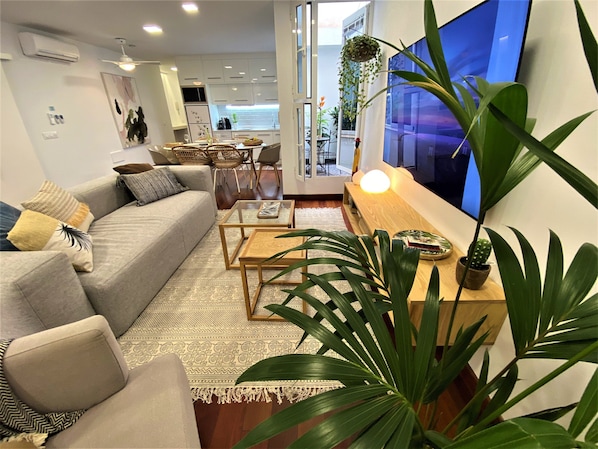 A modern living room with a sofa, coffee table, and a TV.